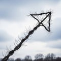 A bare tree branch twists into an arrow shape, pointing upwards against a cloudy sky. Royalty Free Stock Photo
