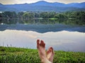 Bare Woman is Feet on The Green Grass. Copy Space. Woman Legs and Feet on Green Grass Near River Royalty Free Stock Photo