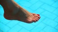 Bare woman feet over swimming pool water Royalty Free Stock Photo