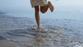 Bare woman legs jumping on sea waves close up. Girl feet splashing in water.