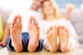 Barefeet of a happy couple lying on a sofa