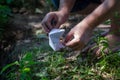 A barefoot adult man lights a paper boat