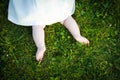Barefoot baby girl on grass exploring
