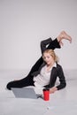 Barefoot ballerina dressed in a business suit poses for a laptop and drinks coffee. Flexible woman works at the computer Royalty Free Stock Photo