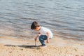 Boy holding stick near wet sand and pond Royalty Free Stock Photo