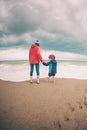 Barefoot boy with mother come into the sea