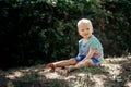 Barefoot boy sits on the sand Royalty Free Stock Photo