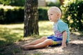 Barefoot boy sits on the sand Royalty Free Stock Photo