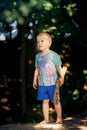 Barefoot boy stands on the sand and holds a stick in his hand Royalty Free Stock Photo