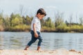 Barefoot boy walking on wet sand near pond Royalty Free Stock Photo