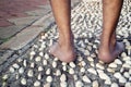 Barefoot at cement stone track for massage the soles of the feet from back