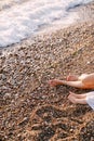 Barefoot female and child feet on a pebble beach by the foaming sea Royalty Free Stock Photo