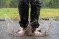 Barefoot female feet jump in a puddle, after rain, spray scatters in different directions. Photo in motion, blur