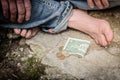 Barefoot foot stepped on the bill or banknote. One dollar on concrete. Money lying on the ground. Poverty concept