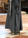 Barefoot friar with sandals in the church