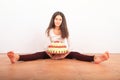 Pretty girl with anniversary cake sitting on floor