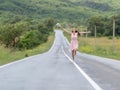 Barefoot girl with chamomile bouquet running along road after ra Royalty Free Stock Photo