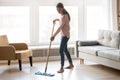 Barefoot girl doing house cleaning using microfiber wet mop pad Royalty Free Stock Photo