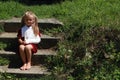 Barefoot girl sitting on the stairs