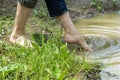 Barefoot girl touches water in a puddle with your foot