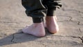 Barefoot girl walks on dry cracked ground, drought Royalty Free Stock Photo