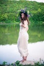 Barefoot girl in a wreath walks to the river Royalty Free Stock Photo