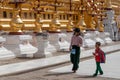 Barefoot kids boy and girl back from school walking clockwise at Shwezigon pagoda with thanaka on their faces. Wearing traditional