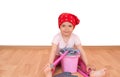 Barefoot little girl with toy cleaning equipment sitting on the floor isolated Royalty Free Stock Photo