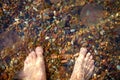 Barefoot male feet on the beach with pebbles Royalty Free Stock Photo