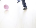 Barefoot male playing with a pink balloon on the floor Royalty Free Stock Photo