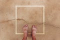 Barefoot male standing on wet concrete surface with square frame as copy space, top view Royalty Free Stock Photo