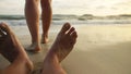 The man feet relaxed are lying on the sandy beach and washed by the water and foam of the ocean. Women& x27;s feet are Royalty Free Stock Photo