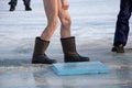 Bare feet in galoshes after swimming in the river in winter on ice at Epiphany