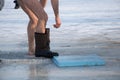 Bare feet in galoshes after swimming in the river in winter on ice at Epiphany