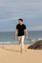 Barefoot man walking on the beach wearing casual Royalty Free Stock Photo