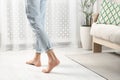 Barefoot man walking on white parquet at home, closeup. Heated floor Royalty Free Stock Photo