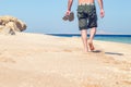 Barefoot man walks along the sandy sea coast Royalty Free Stock Photo