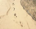 Barefoot marks on beach sand digital illustration. Vintage beach view with smooth sea wave.
