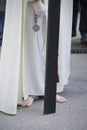 Barefoot penitent doing penance with a wood cross in a Holy week procession