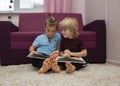 2 barefoot preschool boys are looking at and reading a book together Royalty Free Stock Photo