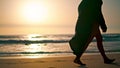 Barefoot girl walking beach sand at summer sunrise. Woman stepping seashore. Royalty Free Stock Photo