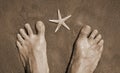 Barefoot on the sand and starfish with sepia toned effect Royalty Free Stock Photo