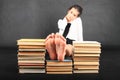 Soles of bare feet of teenage girl on top of old books