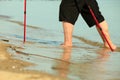 Barefoot senior nordic walking on a beach.