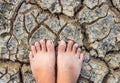 Barefoot standing on dry and cracked ground background