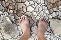 Barefoot standing on dry and cracked ground