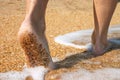 Barefoot in surf on sand coast