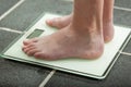 Barefoot teenage boy weighing himself