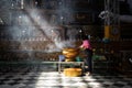 Barefoot woman burning incense as offering to Buddha inside a buddhist temple. Sun rays lighting. Shwe Tha Lyaung, reclining