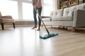 Barefoot woman cleaning floor with wet mop pad cropped image. Royalty Free Stock Photo